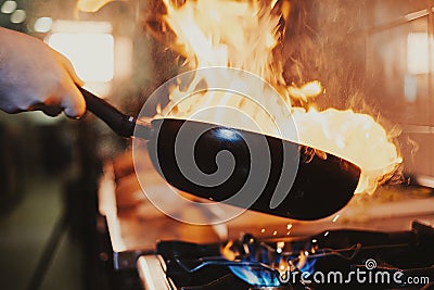 Chef steering flamed frying pan Stock Photo