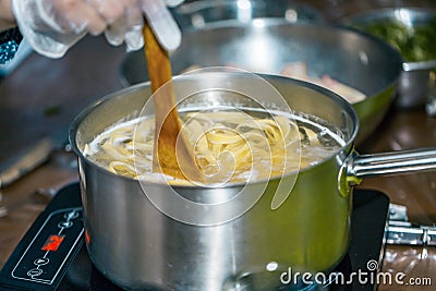 Chef stir Spaghetti in a pot of boiling water. cooking spaghetti. Stock Photo