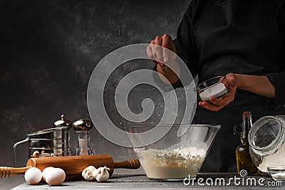 Chef sugars dough for cooking sweet pastries. Freezing in motion. Background for pastry baking. Ingredients for making pastries. Stock Photo
