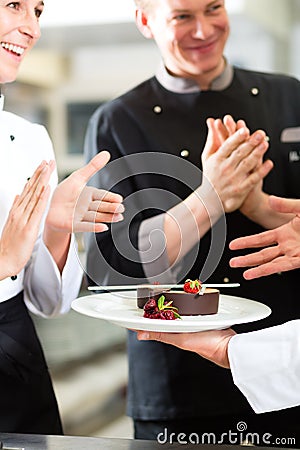 Chef team in restaurant kitchen with dessert Stock Photo