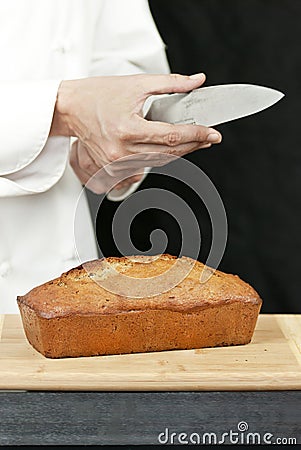 Chef Tests Knife Sharpness Over Banana Bread Stock Photo