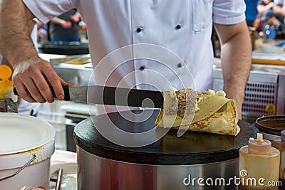 Cheff preparing tasty pancake with wallnuts and cream. Stock Photo