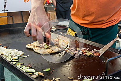 Cheff preparing traditional Mediterranean squid dish on a hot grill. Stock Photo