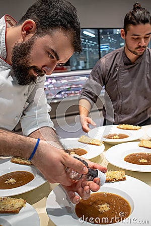 Chefs arranging fresh prepared French onion soup. Stock Photo