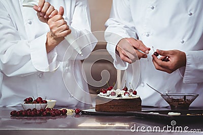 Chefs decorating a cake they just made Stock Photo