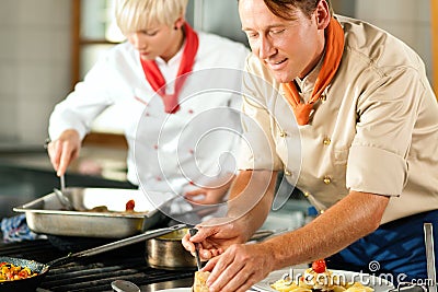 Chefs in a restaurant or hotel kitchen cooking Stock Photo