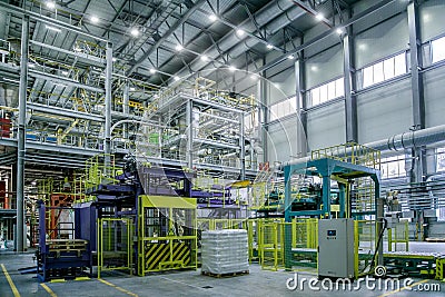 Chemical factory. Thermoplastic production line. Production and packing machinery in large area of industrial hall Stock Photo