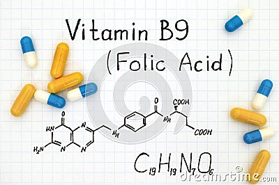 Chemical formula of Vitamin B9 Folic Acid with pills. Stock Photo
