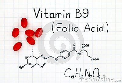 Chemical formula of Vitamin B9 Folic Acid with red pills. Stock Photo