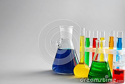 Chemical glassware with colorful samples on light background Stock Photo