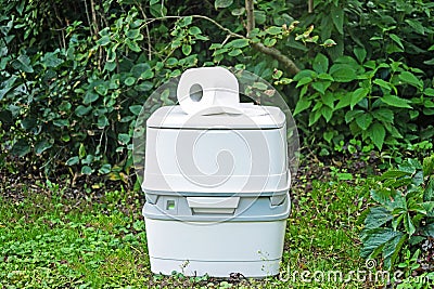 Chemical portable toilet. Single portable toilet standing on green nature courtyard background Stock Photo