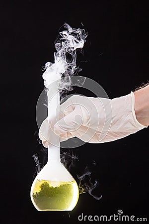 Chemical reaction in volumetric flask glass kept in the hands of Stock Photo