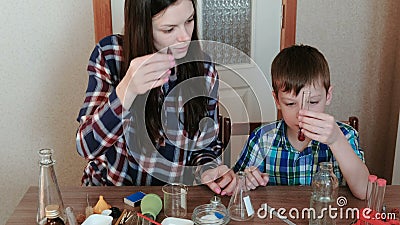 Chemie experimentiert zu Hause Mutter und Sohn tun ein Experiment mit roter Farbe und Wasser stock video Chemie experimentiert zu Hause Mutter und Sohn tun ein Experiment mit roter Farbe und Wasser stock video