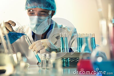 Chemist manipulating a liquid from beaker to a tube Stock Photo