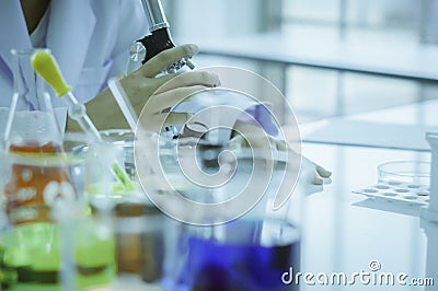 Chemist, microscope, chemical testing in lab, concept for improving safety products before applying to consumers Stock Photo