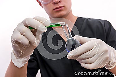 Chemist in protective uniform holding flask and test tube with minerals isolated on white. Science and experiment concept Stock Photo