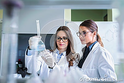 Young female researchers conducting laboratory test Stock Photo