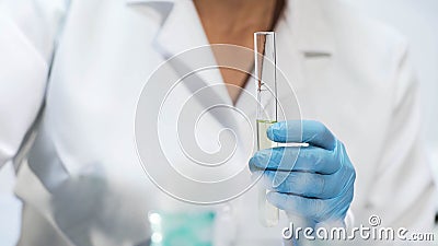 Chemistry student holding test tube with yellow liquid, doing medical research Stock Photo