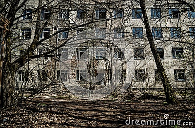 Street of the abandoned ghost town Pripyat. Overgrown trees and collapsing houses in the exclusion zone of the Chernobyl nuclear d Editorial Stock Photo