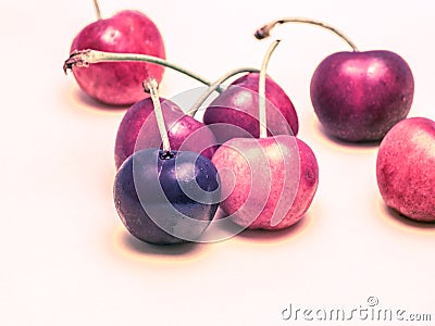 Cherries with artificial, surreal, unnatural, look isolated on bright background. Stock Photo