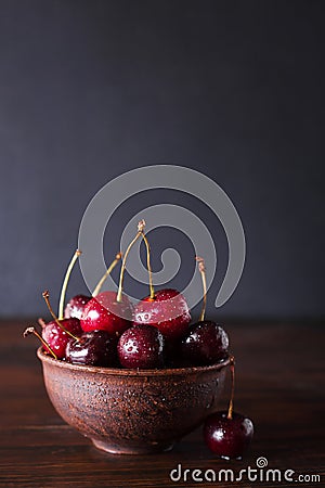 Cherries. Cherry. Cherries in ceramic bowl . Red cherry. Fresh cherries. Cherry on dark background. Stock Photo