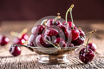 Cherries. Fresh sweet cherries. Delicious cherries with water drops in retro bowl on old oak table Stock Photo