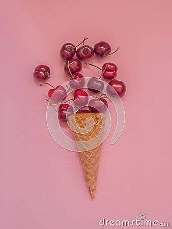 Cherries in a ice cream cone on pink Stock Photo