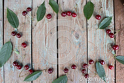 Cherry berry. Harvest cherries on a wooden background. Ripe cherry with green leaves top view Stock Photo