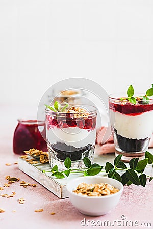 Cherry, cream cheese and chocolate biscuit portion layered dessert in glass, pink background. Black forest trifle. Summer dessert Stock Photo