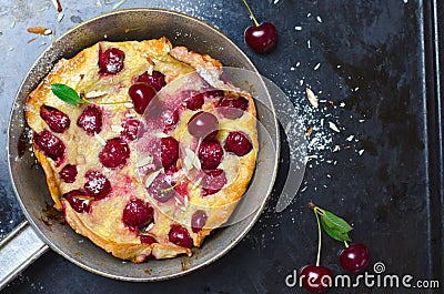 Cherry Dutch Baby, Puff German Pancake on Vintage Pans and Dark Background, Homemade Summer Dessert Stock Photo