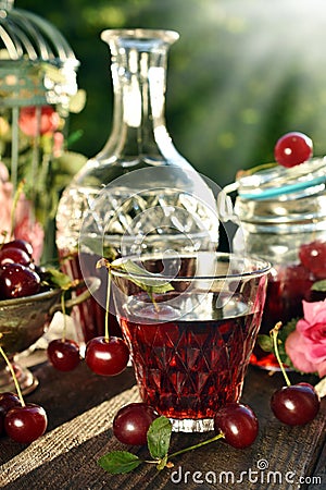 Cherry liqueur in crystal carafe and fresh fruits Stock Photo