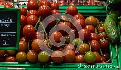 Cherry tomatoes in basket in supermarket, first-person view Stock Photo