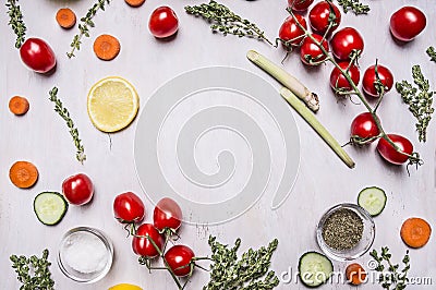 Cherry tomatoes on a branch with Sliced cucumber lemon carrots various herbs seasoning salt lined frame place for text on wooden r Stock Photo