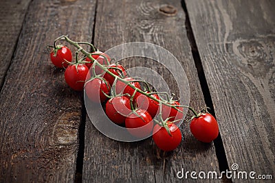 Cherry tomatoes, a bunch of red ripe tomatoes on a wooden background Stock Photo