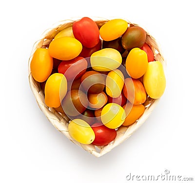 Cherry tomatoes of different colors in the heart shaped woden basket, yellow, orange, red, green Stock Photo