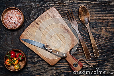 cherry tomatoes, knife and cutting board on a dark wooden table. View from above. Space for text Stock Photo