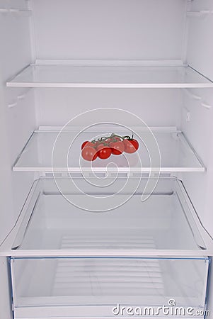 Cherry tomatoes in open empty refrigerator. Stock Photo