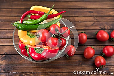 Cherry tomatoes and peppers in bowl on wooden table top texture Stock Photo