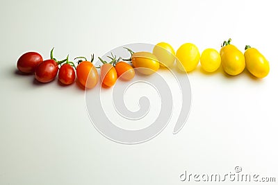 Cherry tomatoes in a row for color nuance on white background Stock Photo