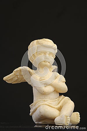 Cherub sitting black backgrounds Stock Photo