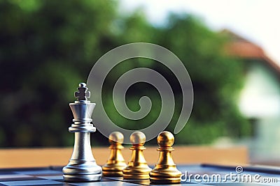 Chess board, silver king stand at front of three pawn Stock Photo