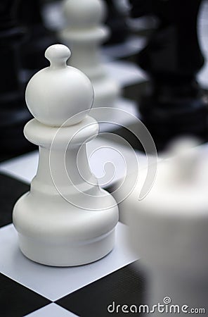 Chess figure - white pawn on outdoor chessboard Stock Photo