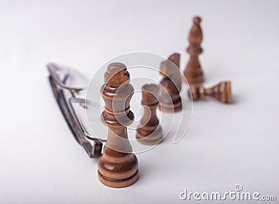 Chess figures with eyeglasse on white background Stock Photo