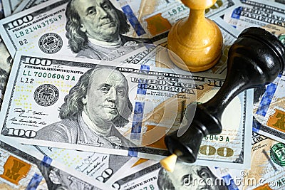 Chess figures on US dollar bills pile, king lies on cash Stock Photo