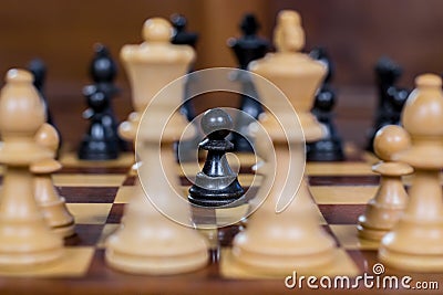 Chess game, close up of a black pawn, white figures in the front Stock Photo