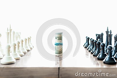 Chess pieces fighting for twisted dollar bills Stock Photo