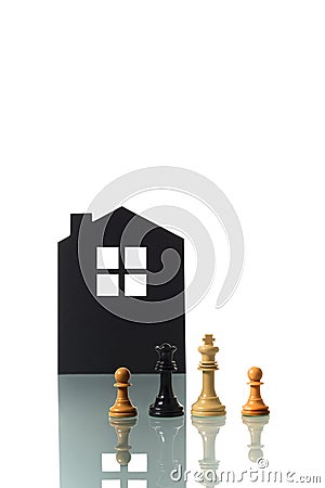 Chess pieces with silhouette of a house in the background Stock Photo