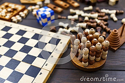 Chess board and chess figures, wooden cubes, puzzle games on dark wooden table. Popular logic games for logical thinking Stock Photo