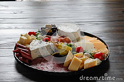 Chesse platter with cheese, prosciutto, tomato, nuts. Healthy eating, dairy, chesses and meat. Antipasti appetizer. Camembert, moz Stock Photo