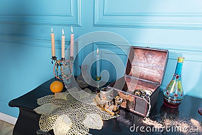 Chest, candles and a bottle on the stele. Stock Photo